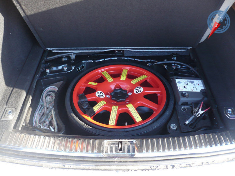 Докатка ярко красного цвета прячется под полом багажного отделения