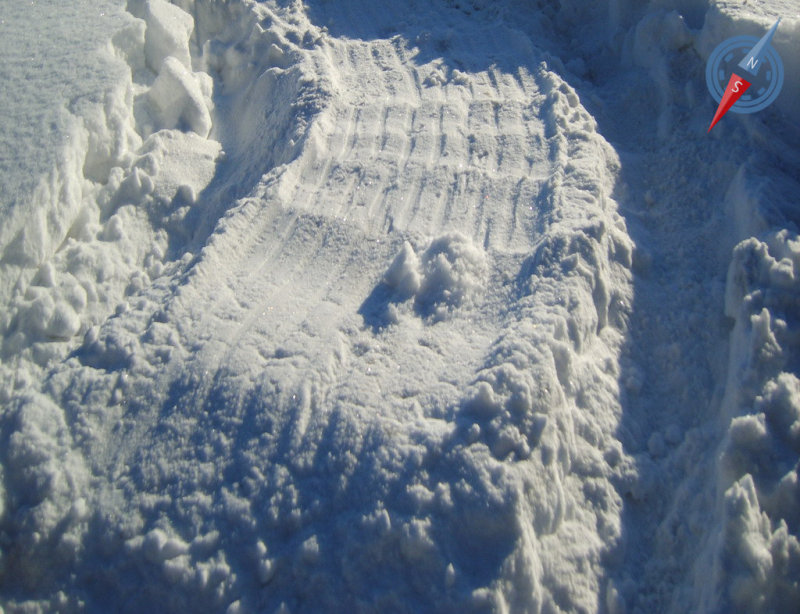 Подобную разметку, в виде параллельных полос на снегу, оставляет банка глушителя, расположенная непосредственно в заднем свесе