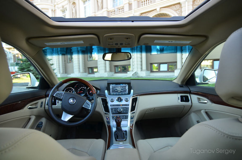 Традиционное американское сочетание материалов в салоне, когда рядом соседствуют мягкая кожа и «дубовый» пластик в CTS второго поколения осталось, но стало менее выраженным диссонансом, чем в предшественнике. В седане нынешней генерации верхняя часть панели обшита нежной кожей, а центральная консоль и детали вставок руля отделаны пластиком под алюминий и дерево (отделка под дерево – опция) внешне очень похожим на настоящие материалы, по факту являющимися просто пластмассой.