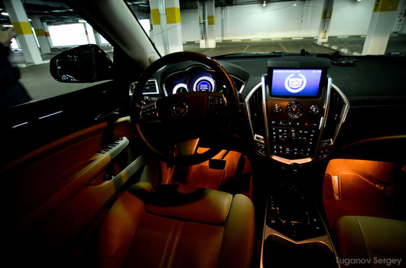 В салоне нового Кадиллака SRX действительно уютно. Американцы, наконец, отказались от привычки сочетать излишне мягкую кожу салона с дубовой и гулкой пластмассой. Панель обшита мягкой и приятной кожей, а на углах украшена контрастным швом!