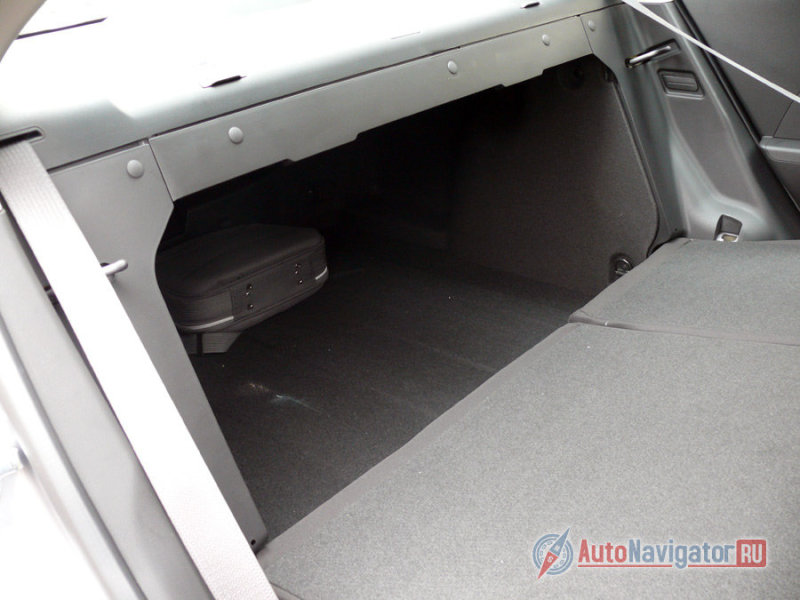 Но есть у багажника седана и пару огорчающих моментов. Складывающиеся спинки задних сидений не образуют ровного пола. В месте стыка – сильно мешающая высокая ступень. А еще высокие петли багажника заставляют частично пожертвовать грузом.