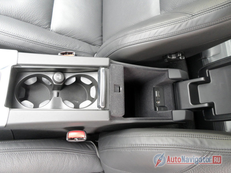 Между передними креслами расположены два бокса: первый скрывает держатели для бутылок, второй - нишу для мелочей