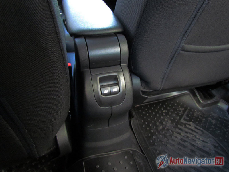 Кнопка задних стеклоподъемников в ногах среднего пассажира второго ряда сидений