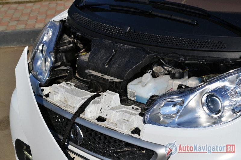 Капот пластиковый и держится на веревочке, как варежки у первоклассников. Открыть и закрыть его одному без сноровки не так-то просто. Двигателя, кстати, тут вы не увидите, он сзади. Спереди только всякие заливные ёмкости