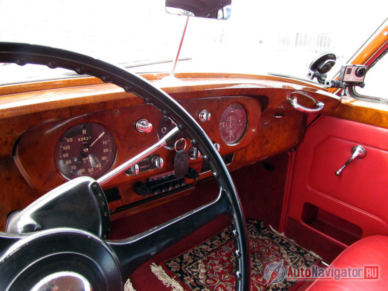 Справа от него –селектор четырехступенчатой АКПП. Обратите внимание, режима «Parking» нет, автомобиль следует оставлять на нейтральной передаче и стояночном тормозе, который включается ручкой слева, внизу. Замок зажигания посреди, ровно как и приборы. Разглядывать эти цифры и стрелочки можно бесконечно. В свое время над этими циферблатами трудились мастера английской фирмы Smiths. Простота и роскошь в них соединены воедино, а сейчас, в дополнении ко всему, они передают запах истории, субъективно, еще довоенной эпохи. Ни один дисплей с искусственными «колодцами» в современной топ-модели премиум-класса не дарит такой эмоциональной подпитки