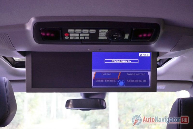 Экран расположен так, что картинка одинаково хорошо видна пассажирам второго и третьего ряда. При этом экран можно разделить на две части, так чтобы слева, например, шел фильм с жесткого диска, а справа сериала со смартфона через разъем HDMI. Для пульта есть собственное место, чтобы он не потерялся, но при желании его можно снять