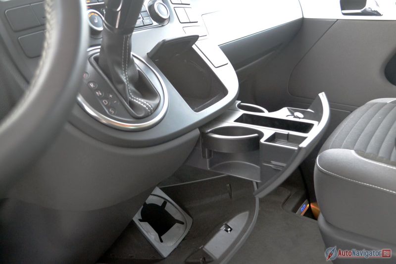 Недостатка в подстаканниках и маленьких выемках для мелочевки нет. Внизу есть большое отделение для бутылки, плюс объемные карманы в дверя