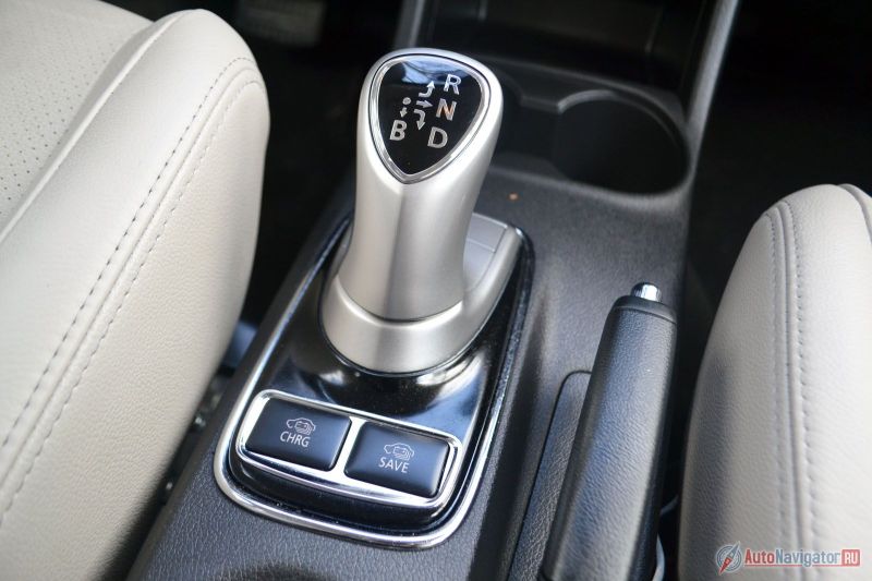 Вместо привычного рычага КПП тут джойстик. А в качестве трансмиссии редуктор, как у троллейбуса. Этим же джойстиком выбирается степень рекуперации энергии при торможении. Если выбрать максимальную, то тормозами вообще почти не пользуешься – отпускаешь газ и машина довольно интенсивно, но плавно замедляется, подзаряжая при этом аккумуляторы. Рядом две кнопки. Левая – заставляет работать ДВС как генератор, заряжая батарею, правая – сохраняет заряд батареи и машина движется исключительно за счет бензина