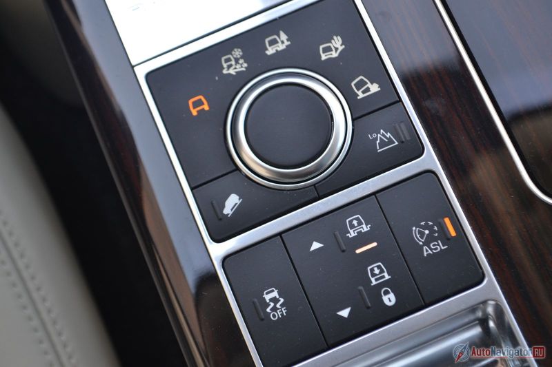 По бокам от шайбы системы Terrain Response расположены кнопки системы контроля спуска и включении пониженной передачи. Чуть ниже кнопки отключения системы стабилизации, регулировки высоты подвески и ограничитель скорости