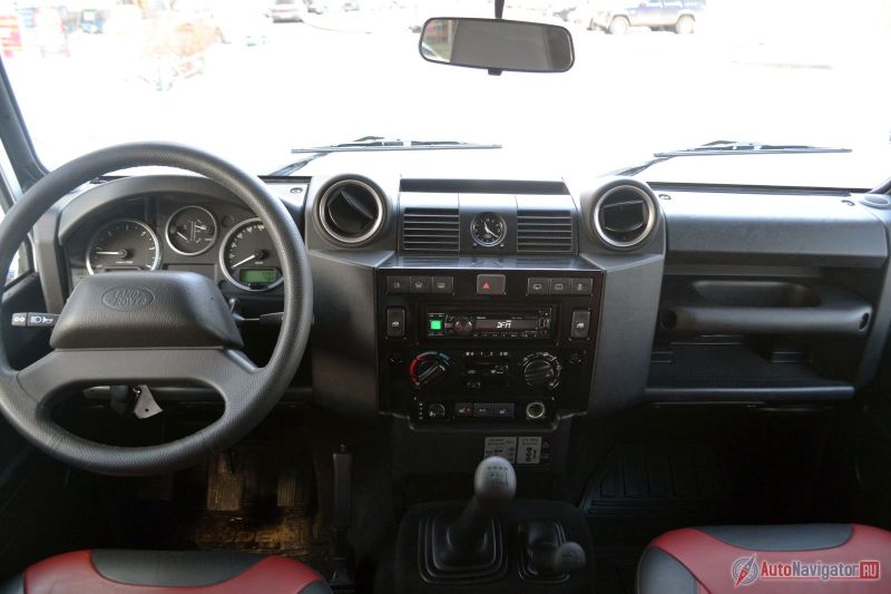 Салон, очевидно, родом из прошлого столетия. Вместо климат-контроля - кондиционер, вместо встроенной музыки - магнитола Alpine, вместо шайбы Terrain Response - «кочерга»