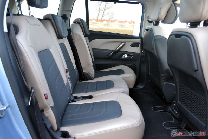 Средний ряд сидений регулируется. В спинки передних кресел встроены откидные столики с подстаканниками и индивидуальным освещением. Есть также резиночка для фиксации чего-то и сетка внизу