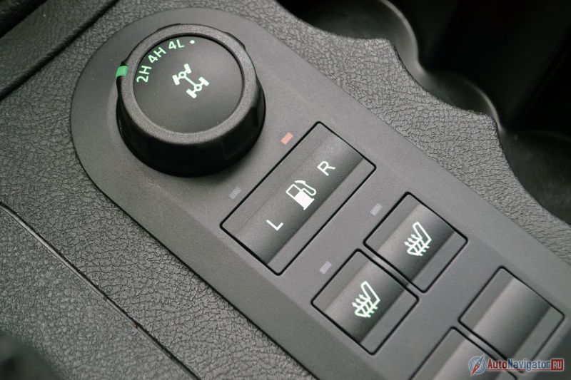 Передняя ось и пониженная теперь включаются шайбой. Бензобака по-прежнему два (общая емкость 72 литра). Есть подогрев сидений (причем не только передних, но и задних). Справа несколько подстаканников, но литровая бутылка туда, например, не влезает. И в дверные карманы тоже. Так что нужно запасаться полулитровыми бутылочками