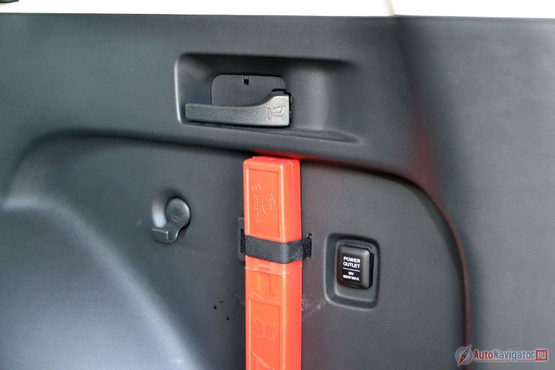 Вот та самая ручка, за которую нужно дернуть, чтобы получился огромный багажник с ровным полом. Тут же крючки и розетка на 12 Вольт