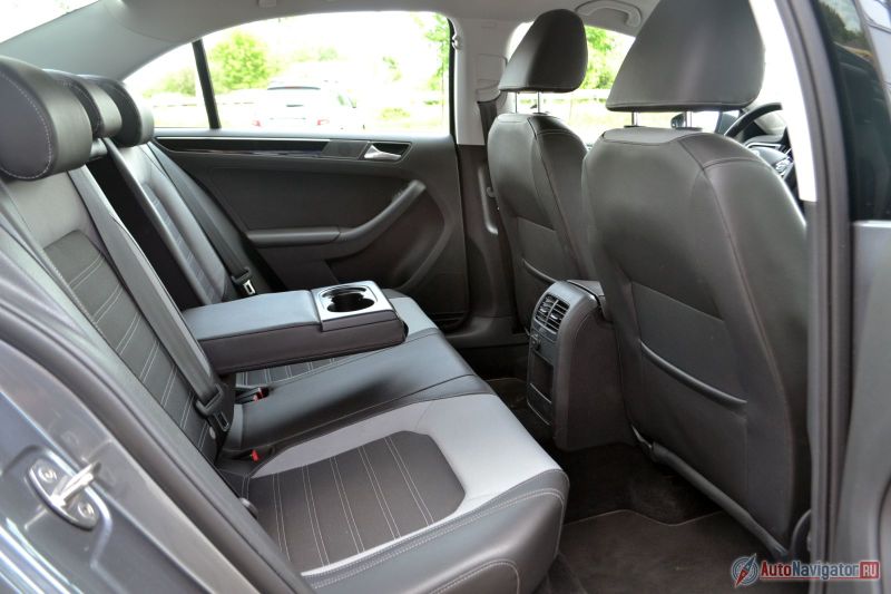 Сзади просторно и есть все удобства: подлокотник с подстаканниками, индивидуальные дефлекторы обдува, розетка на 12V, а под ней кармашек, чтобы можно было телефон на зарядку поставить. Мелочь? А приятно. Судя по цифрам, Jetta проигрывает по величине колесной базы почти всем своим конкурентам, но почувствовать это физически вряд ли удастся. Не тесно!