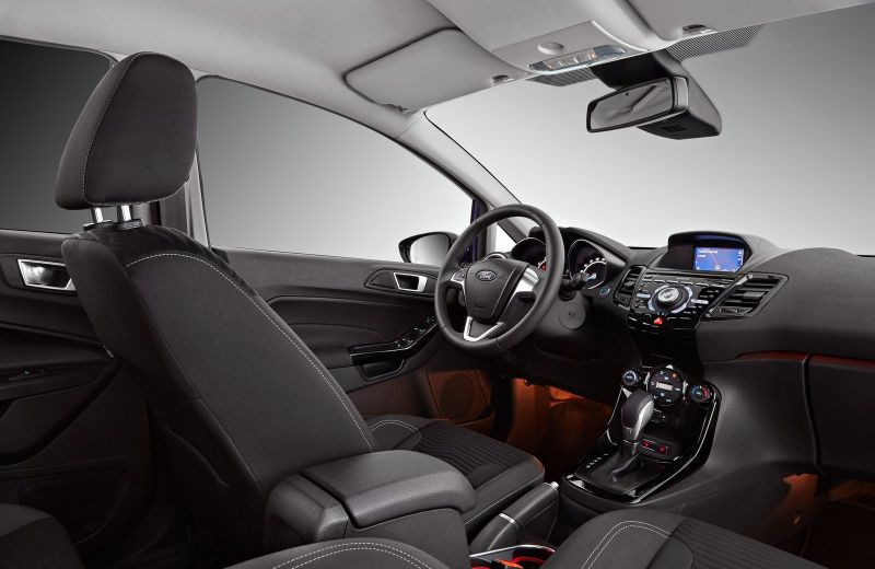 А это салон самой дорогой серии Titanium. Тут фоновая подсветка, иное оформление центральной консоли, а также более дорогая фурнитура, к примеру, ручник