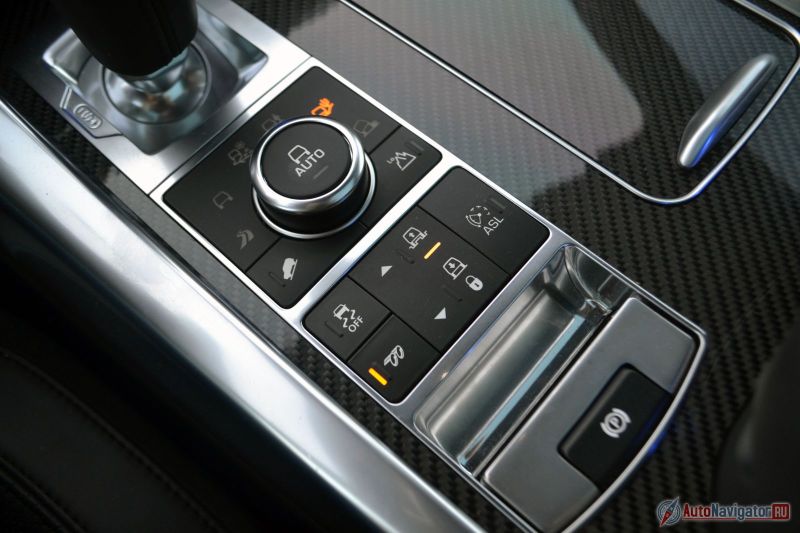 Самые интересные кнопочки тут. Шайба системы Terrain Response, регулировка клиренса, ограничитель скорости, отключение системы стабилизации и волшебная кнопка, которая делает звук выхлопа громче и сочнее