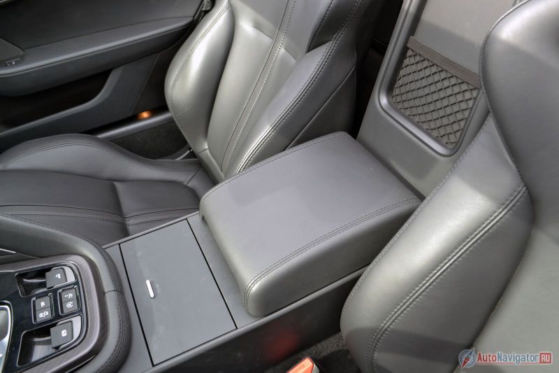 За сиденьями, к сожалению, нет никакой полочки или бокса, куда можно было бы кинуть сумку, куртку или еще что-нибудь. Зато есть подстаканники и небольшой отсек под подлокотником