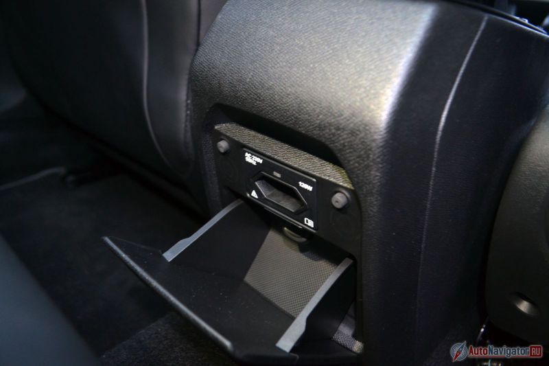 Для задних пассажиров USB не предусмотрен, зато есть полноценная розетка на 220 Вольт. Только нужно захватить переходник для вилки