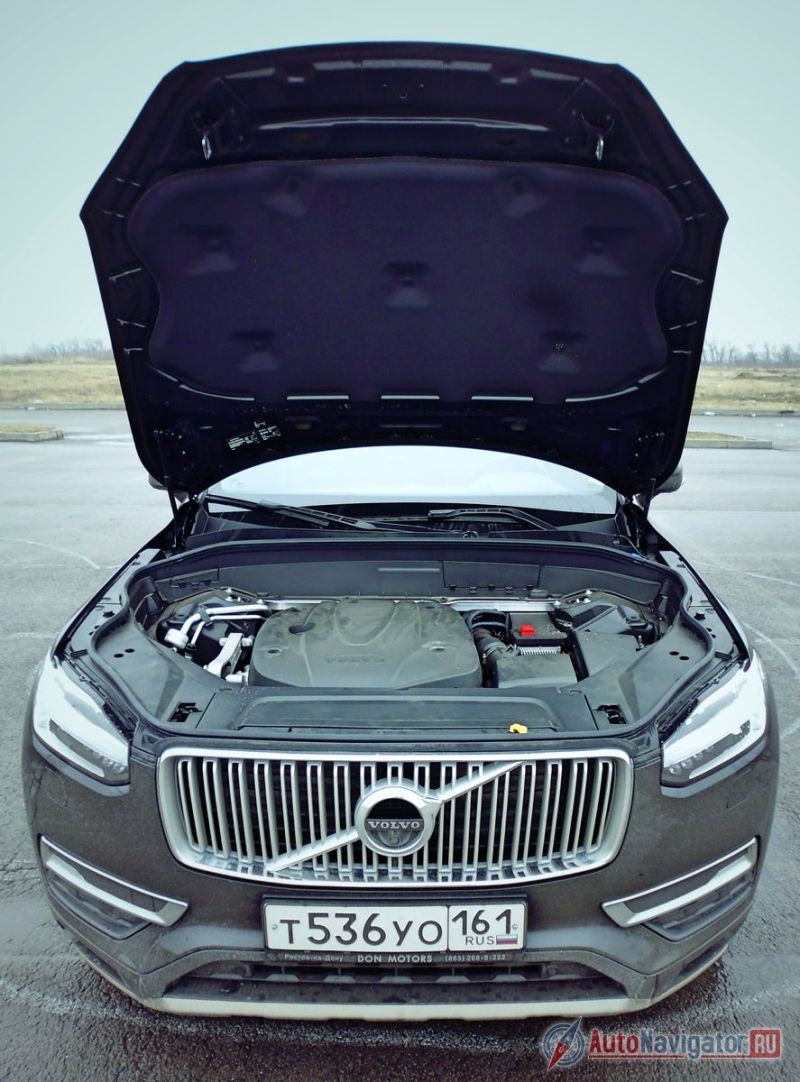 Человека, стоящего рядом с бампером XC90, от мотора отделяет широченная «стена», принимающая на себя основной удар при фронтальном столкновении. Дотянуться до передней кромки поднятого вверх капота, находясь спереди автомобиля, при росте до 190 см практически невозможно, приходится хватать его за одну из боковин